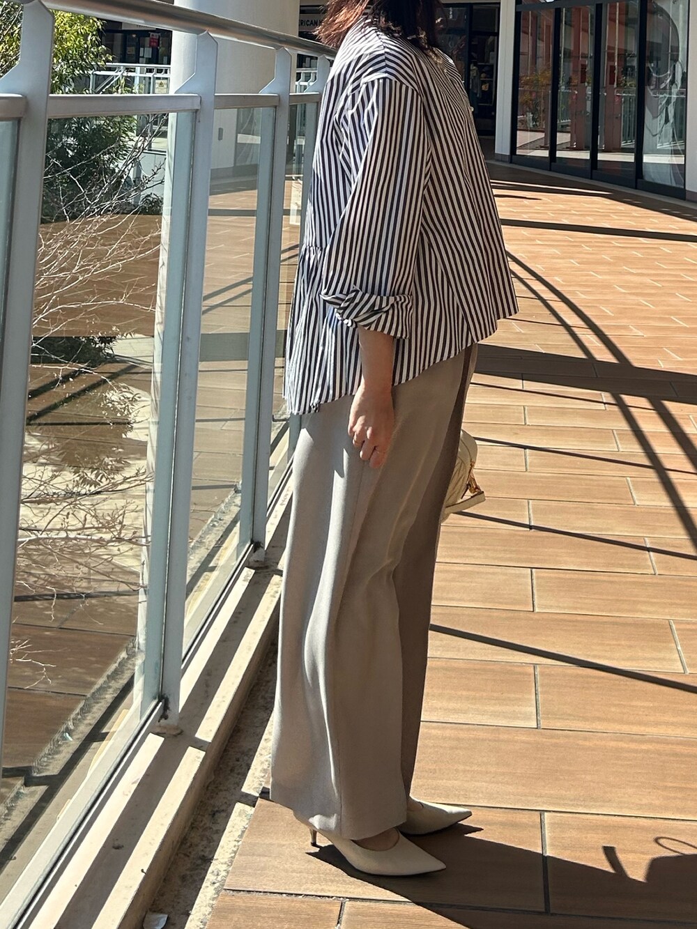 ベージュ系のその他パンツ、グレー系のシャツ/ブラウスを着用したレディースの春コーディネートの2枚目の写真