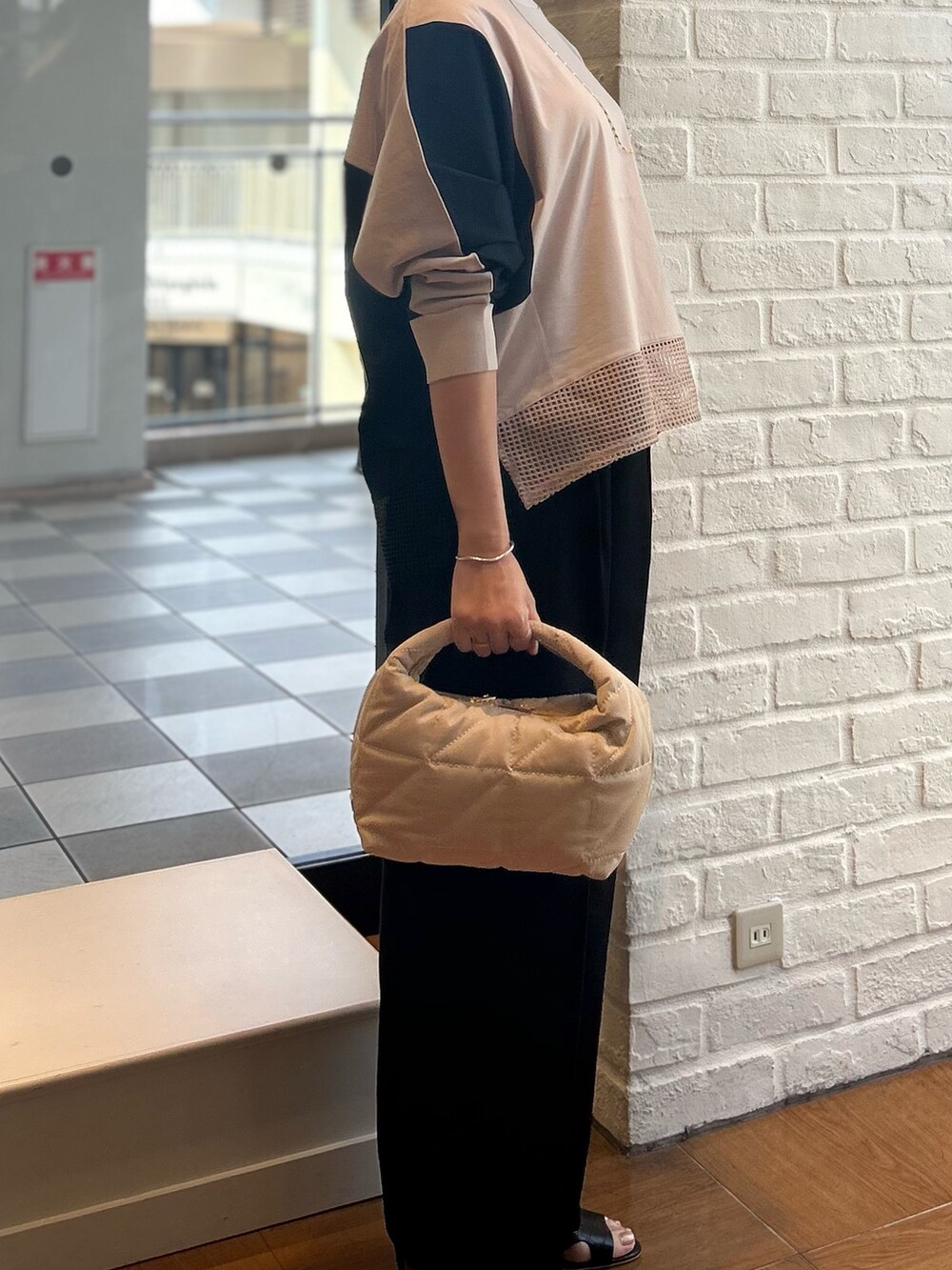 ベージュ系のTシャツ/カットソーを着用したレディースの夏コーディネートの2枚目の写真