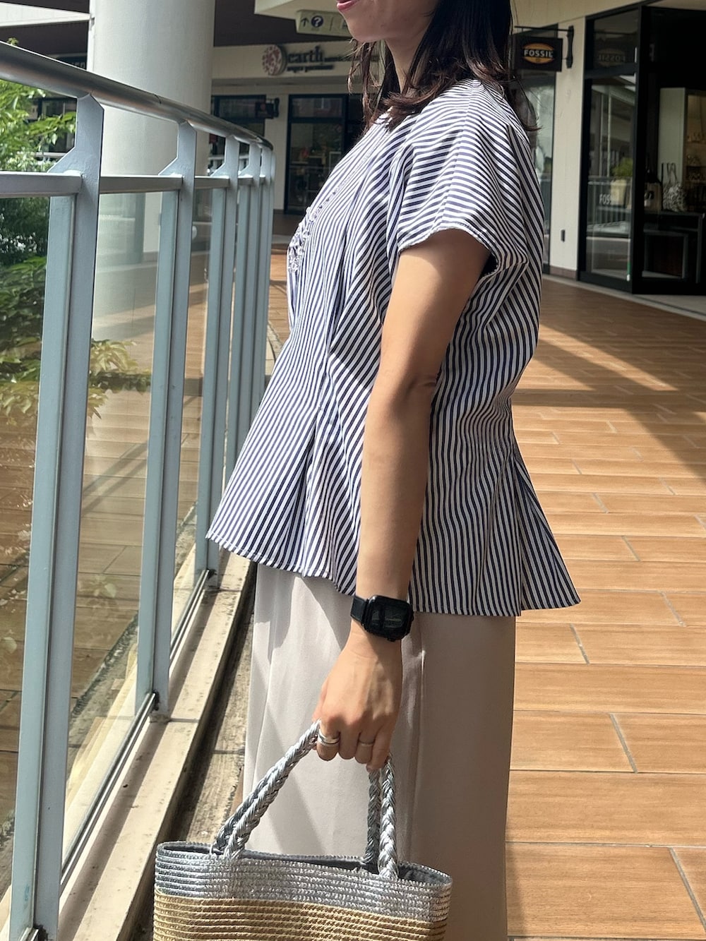 ベージュ系のスカート、ブルー系のシャツ/ブラウスを着用したレディースの夏コーディネートの5枚目の写真