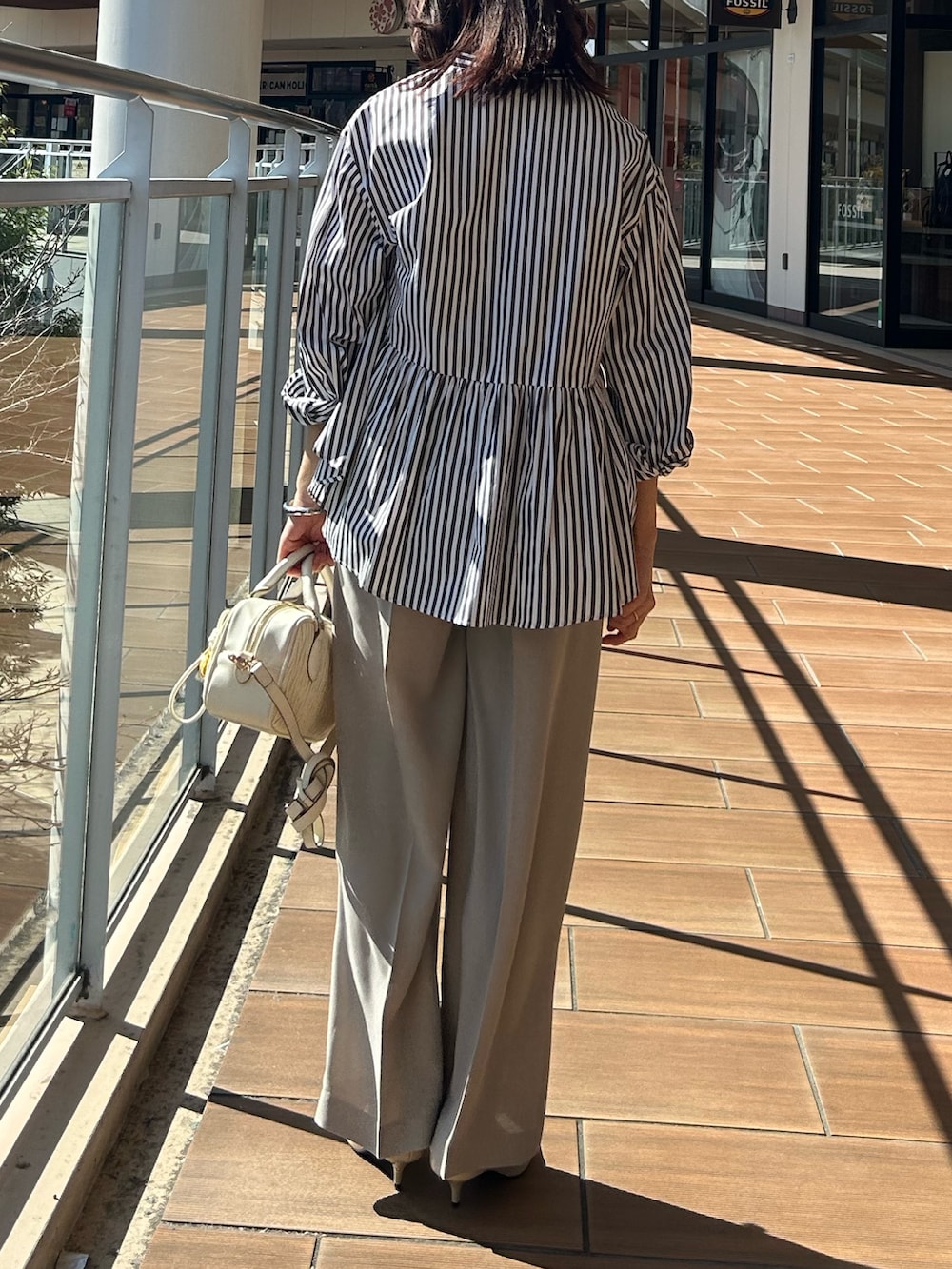 ベージュ系のその他パンツ、グレー系のシャツ/ブラウスを着用したレディースの春コーディネートの3枚目の写真