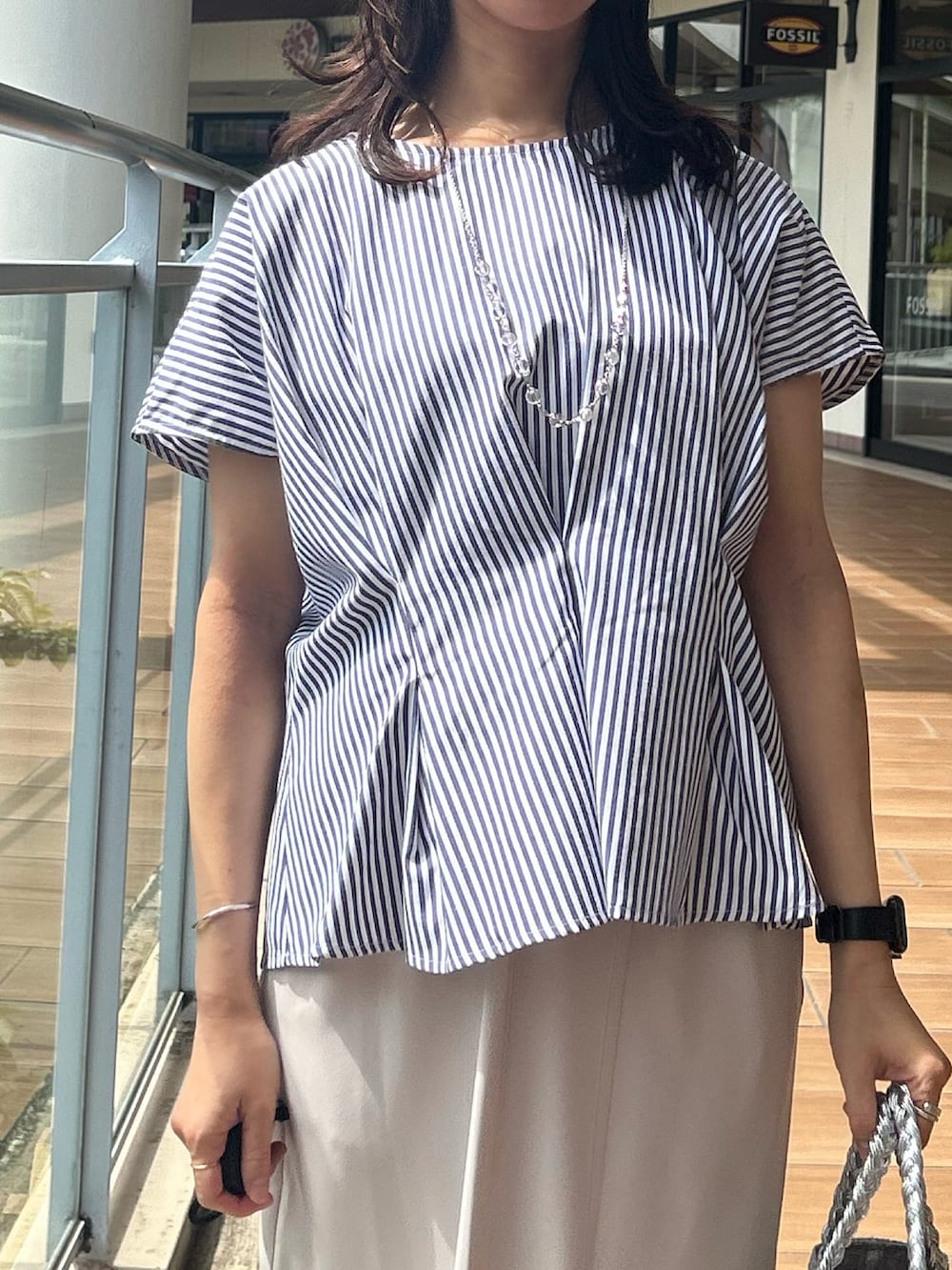 ベージュ系のスカート、ブルー系のシャツ/ブラウスを着用したレディースの夏コーディネートの4枚目の写真