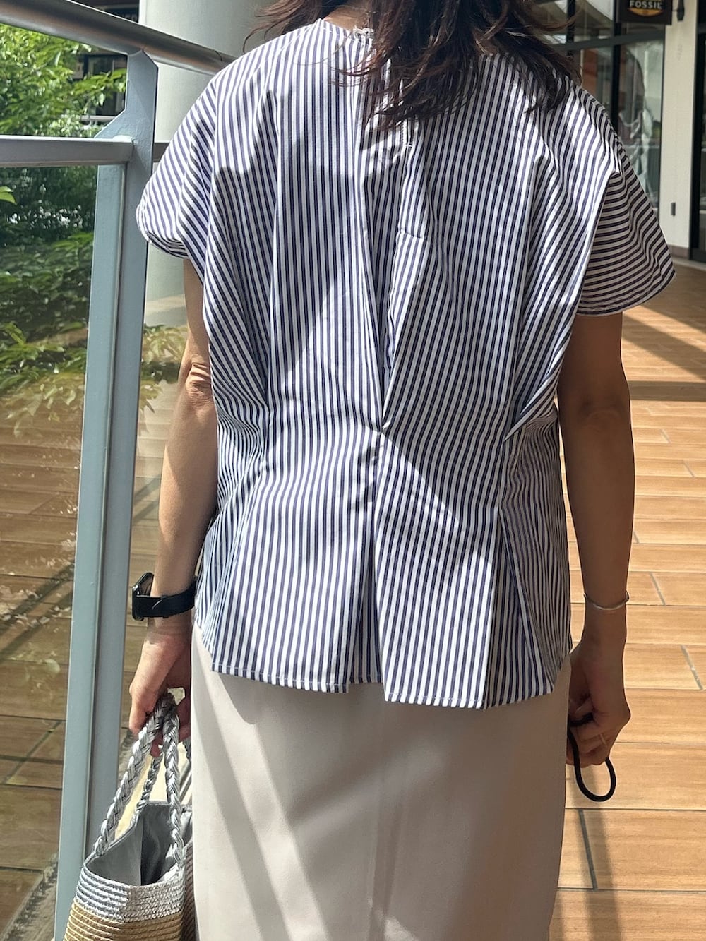 ベージュ系のスカート、ブルー系のシャツ/ブラウスを着用したレディースの夏コーディネートの6枚目の写真