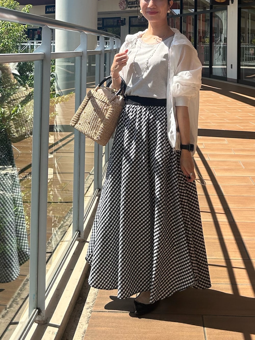 グレー系のTシャツ/カットソー、ホワイト系のブルゾン、ブラック系のスカートを着用したレディースの春コーディネートの7枚目の写真