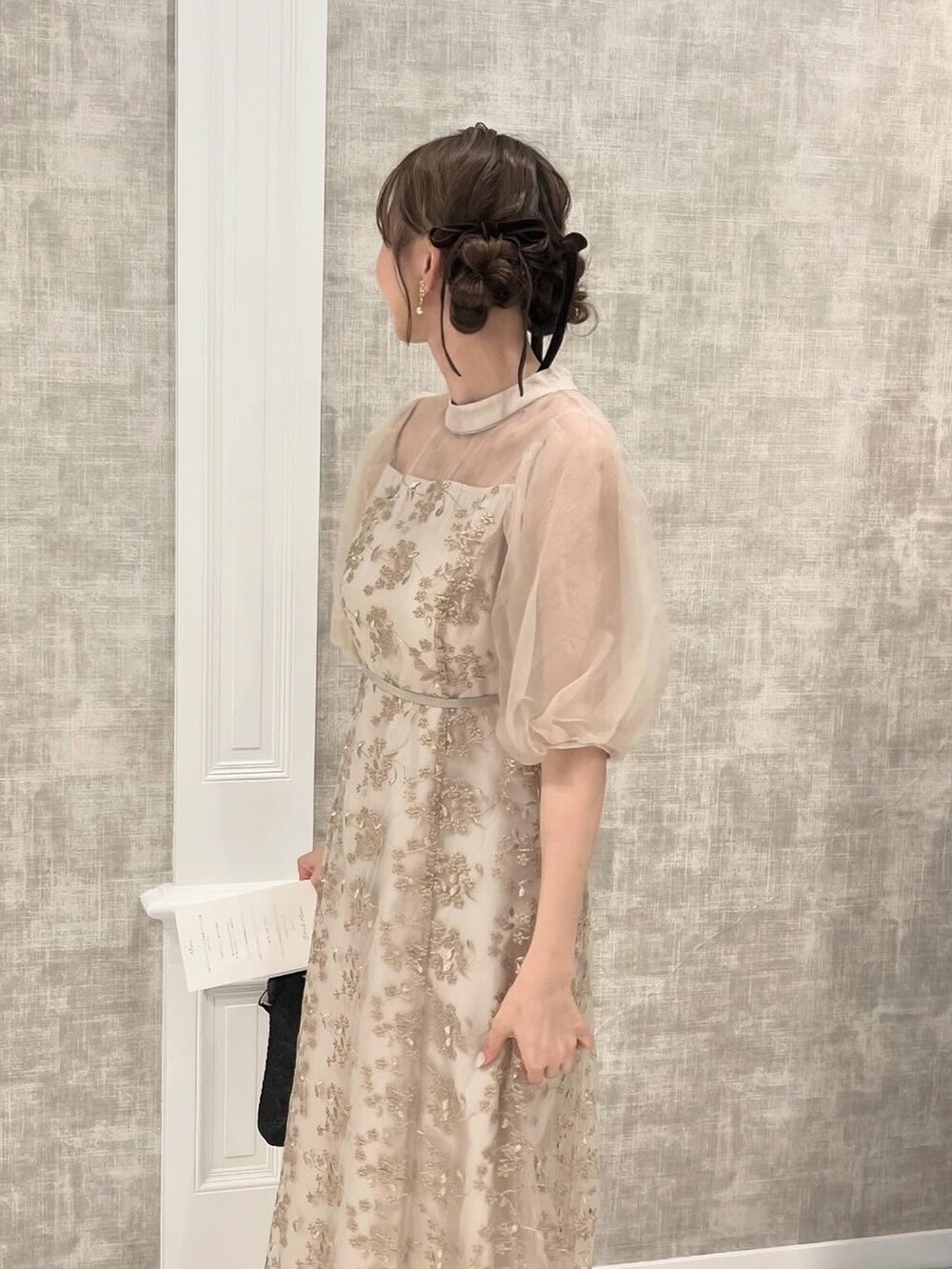 ベージュ系のドレス、ブラック系のハンドバッグ、ホワイト系のその他を着用したレディースの秋コーディネートの2枚目の写真