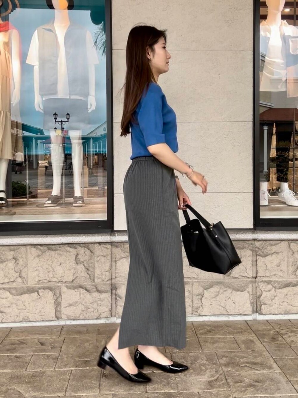 ブルー系のニット/セーター、グレー系のスカートを着用したレディースの秋コーディネートの5枚目の写真