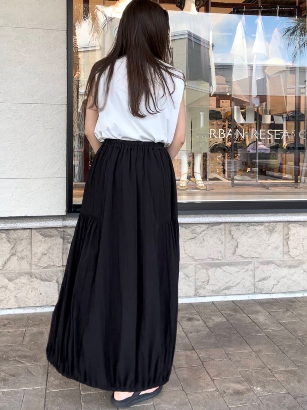 ブラック系のボストンバッグ、ホワイト系のTシャツ/カットソー、ブラック系のスカートを着用したレディースの夏コーディネートの7枚目の写真