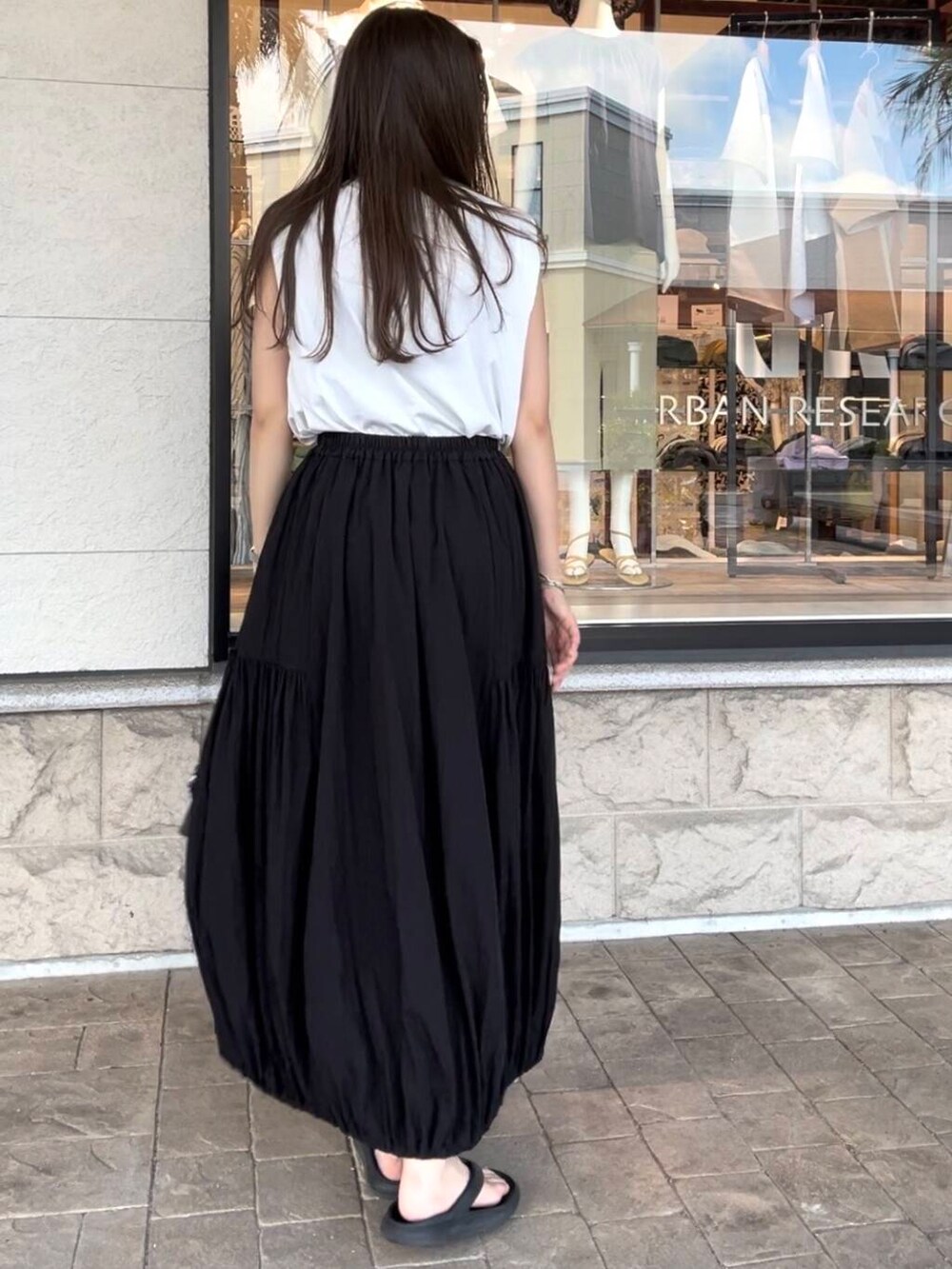 ブラック系のボストンバッグ、ホワイト系のTシャツ/カットソー、ブラック系のスカートを着用したレディースの夏コーディネートの6枚目の写真