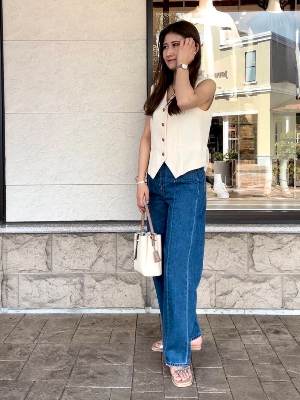 ブルー系のデニムパンツを着用したレディースの夏コーディネートの3枚目の写真