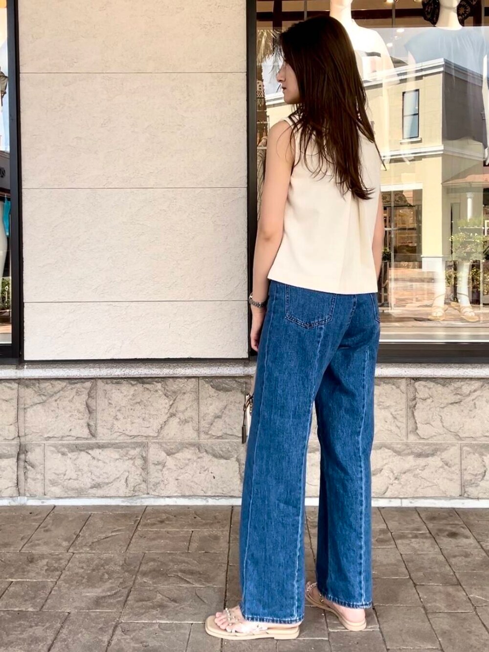 ブルー系のデニムパンツを着用したレディースの夏コーディネートの5枚目の写真