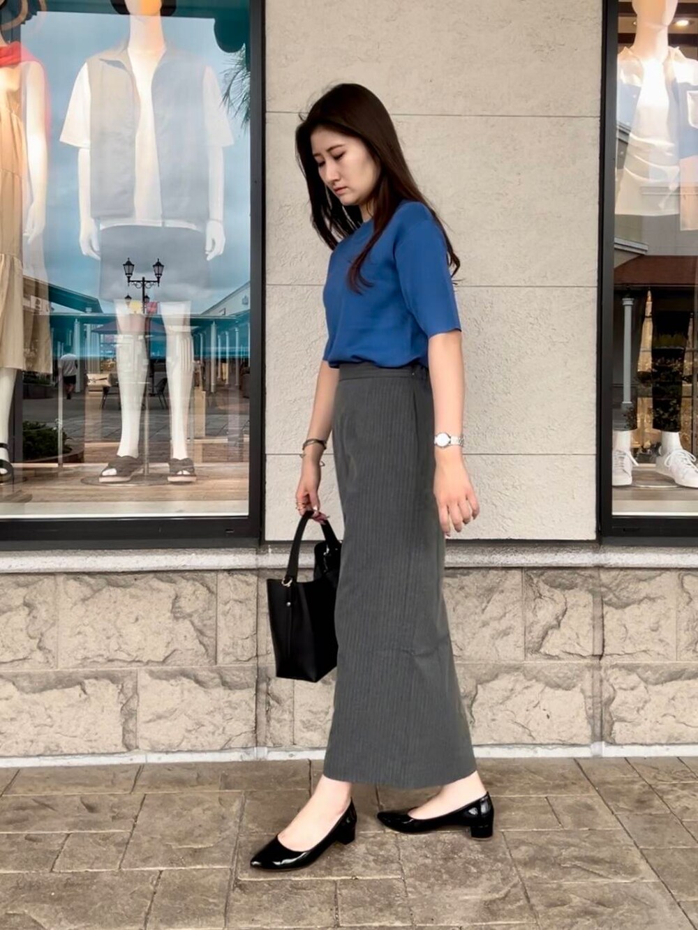 ブルー系のニット/セーター、グレー系のスカートを着用したレディースの秋コーディネートの3枚目の写真