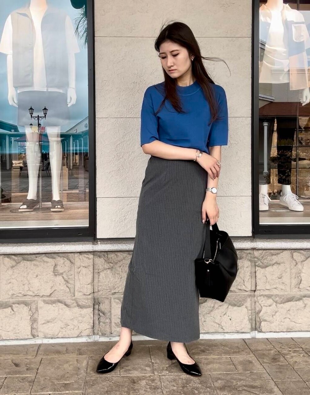 ブルー系のニット/セーター、グレー系のスカートを着用したレディースの秋コーディネートの4枚目の写真