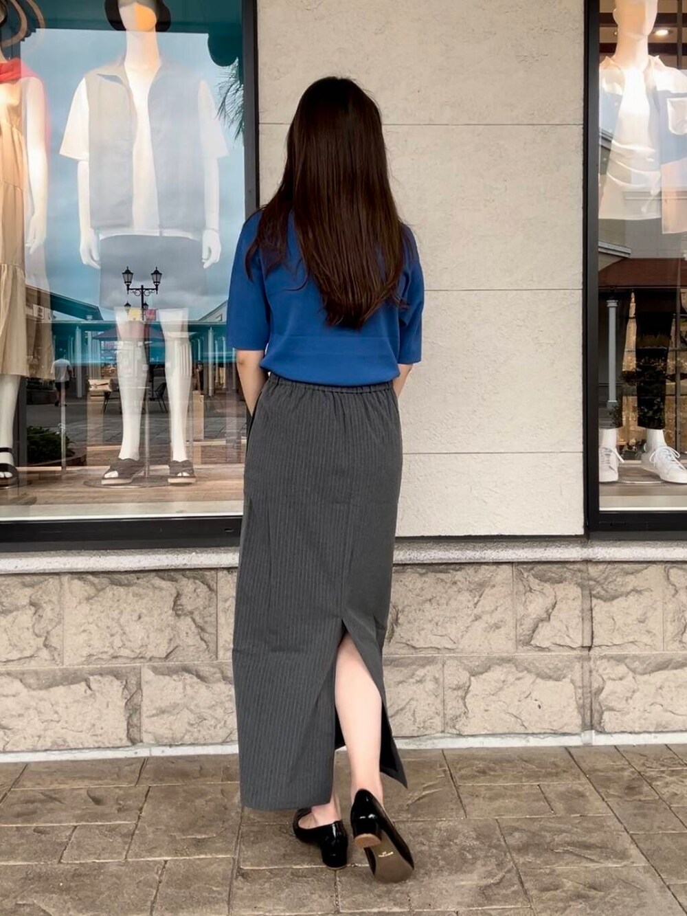 ブルー系のニット/セーター、グレー系のスカートを着用したレディースの秋コーディネートの6枚目の写真