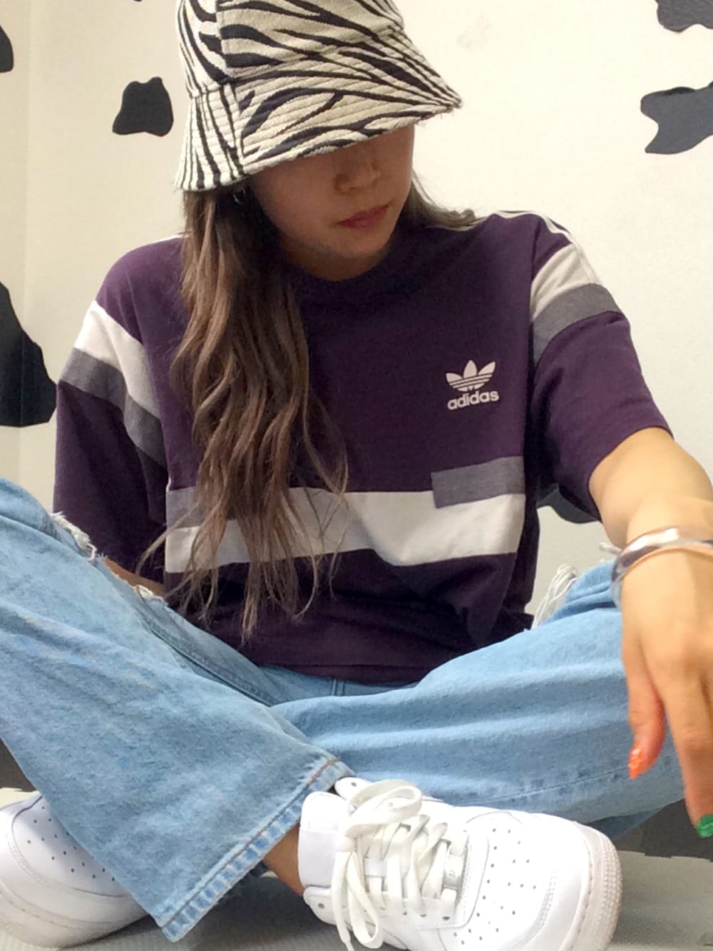 パープル系のTシャツ/カットソー、ホワイト系のクラッチバッグ、ブルー系のデニムパンツを着用したレディースの春コーディネートの3枚目の写真