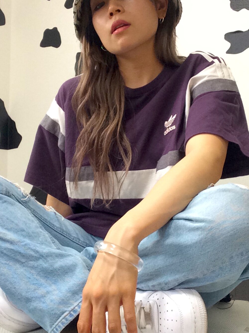 パープル系のTシャツ/カットソー、ホワイト系のクラッチバッグ、ブルー系のデニムパンツを着用したレディースの春コーディネートの4枚目の写真