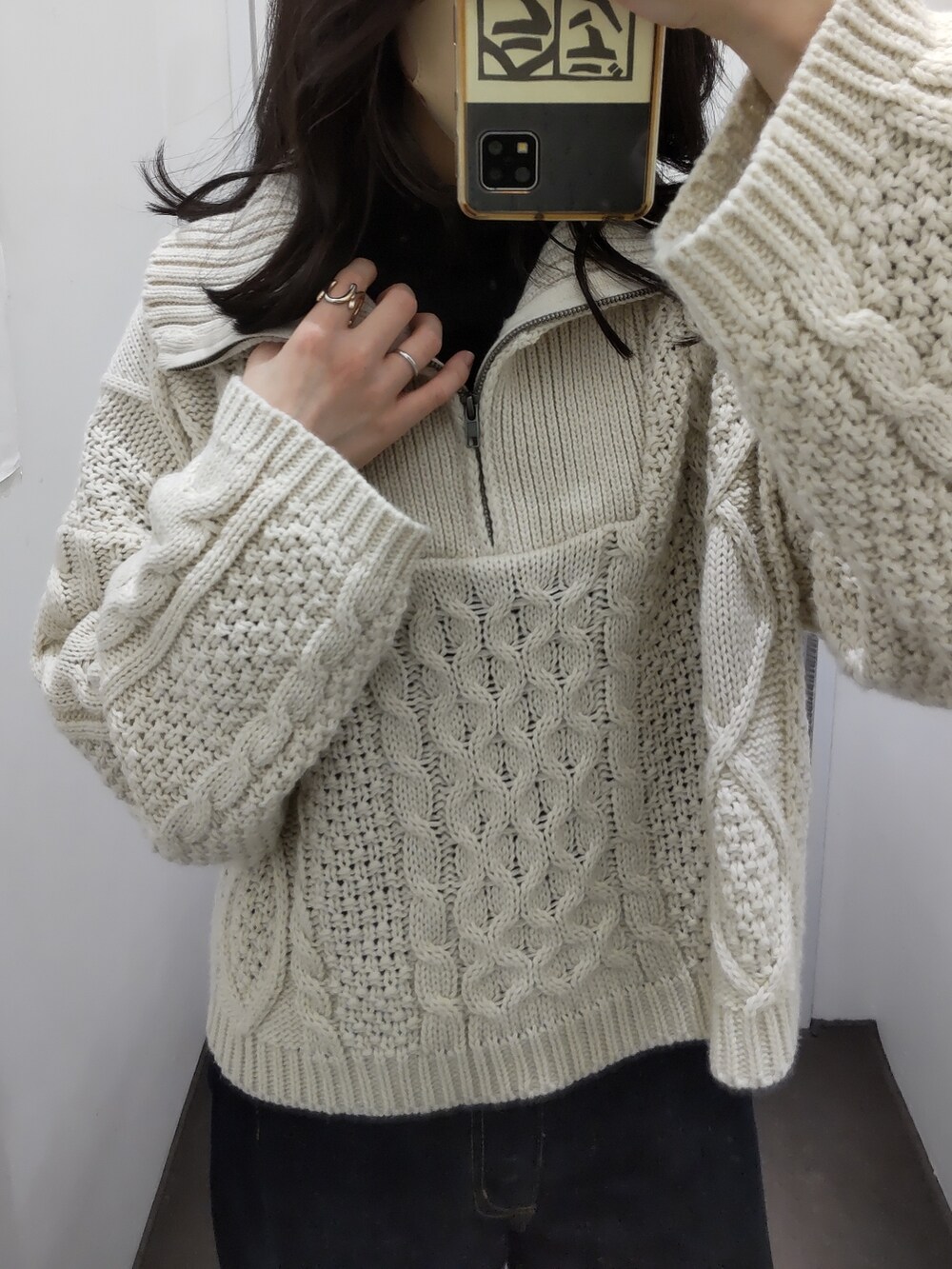 ブルー系のデニムパンツ、ホワイト系のニット/セーター、ブラック系のトップスを着用したレディースの冬コーディネートの2枚目の写真