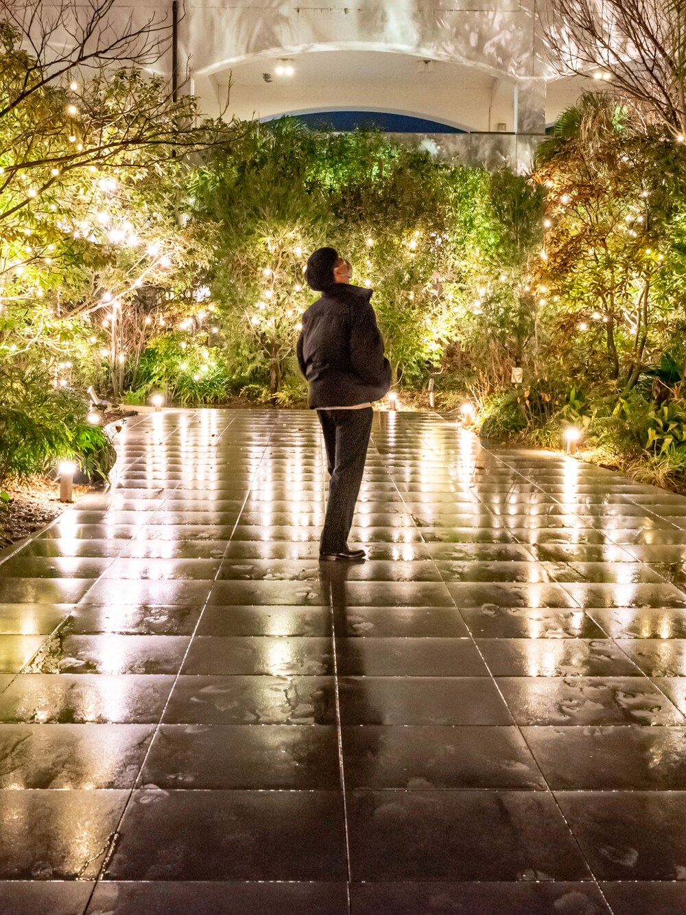 ブラック系のスラックス、ホワイト系のダウンジャケット/コート、ブラック系のブーツを着用したメンズの冬コーディネートの2枚目の写真