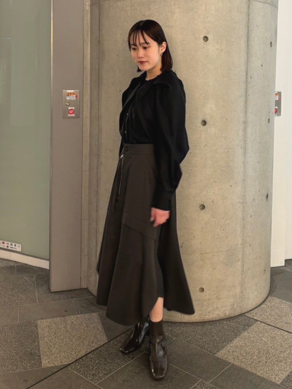 グレー系のスカートを着用したレディースの冬コーディネートの2枚目の写真