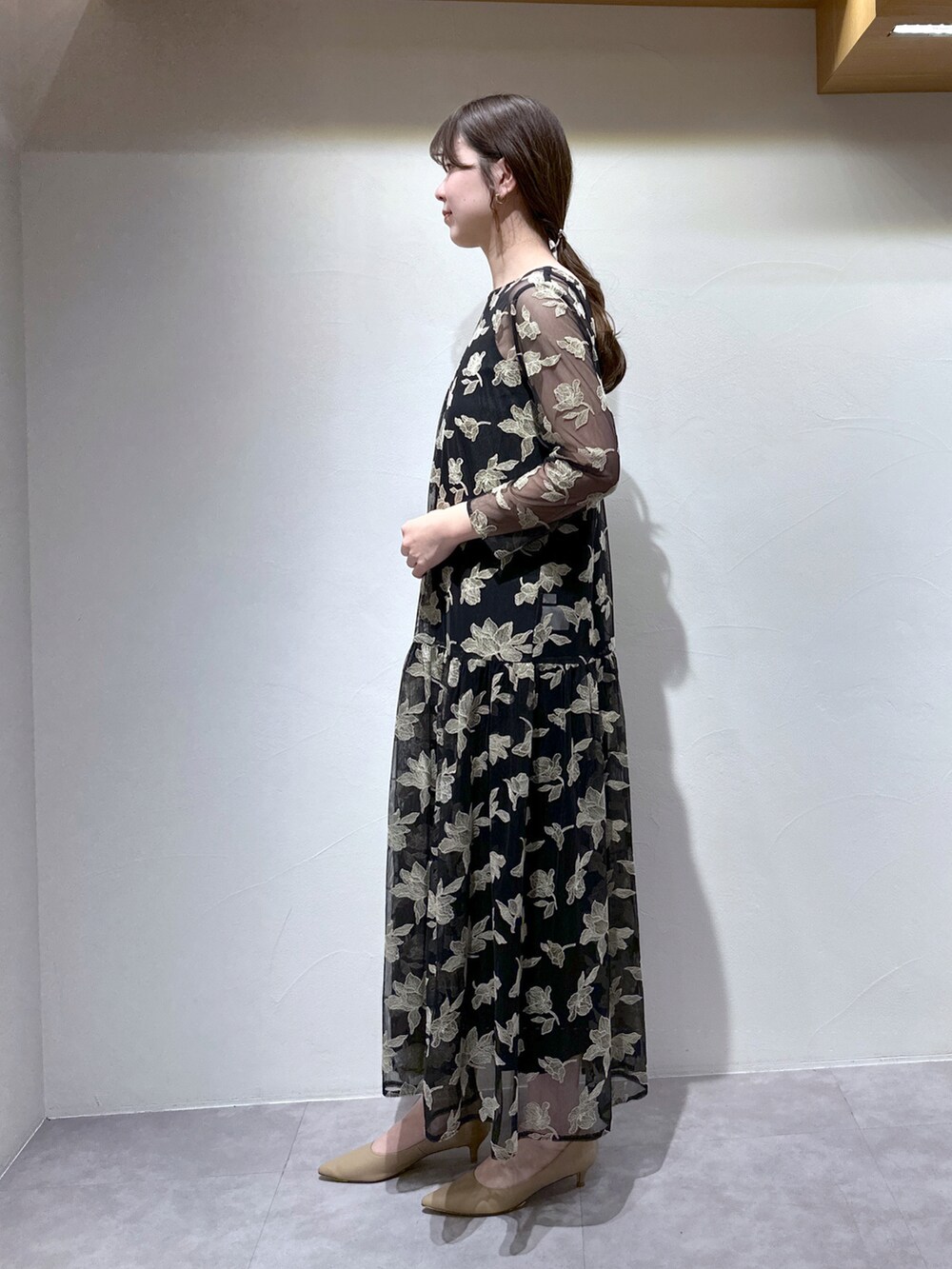 ブラック系のワンピース、パープル系のトートバッグ、ベージュ系のパンプスを着用したレディースの冬コーディネートの3枚目の写真