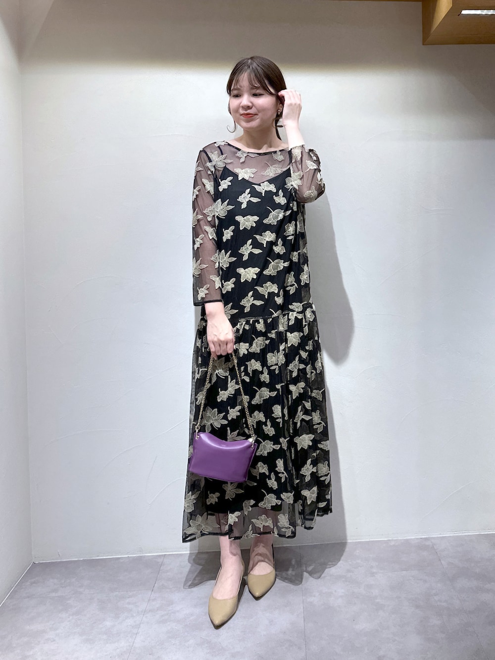 ブラック系のワンピース、パープル系のトートバッグ、ベージュ系のパンプスを着用したレディースの冬コーディネートの2枚目の写真