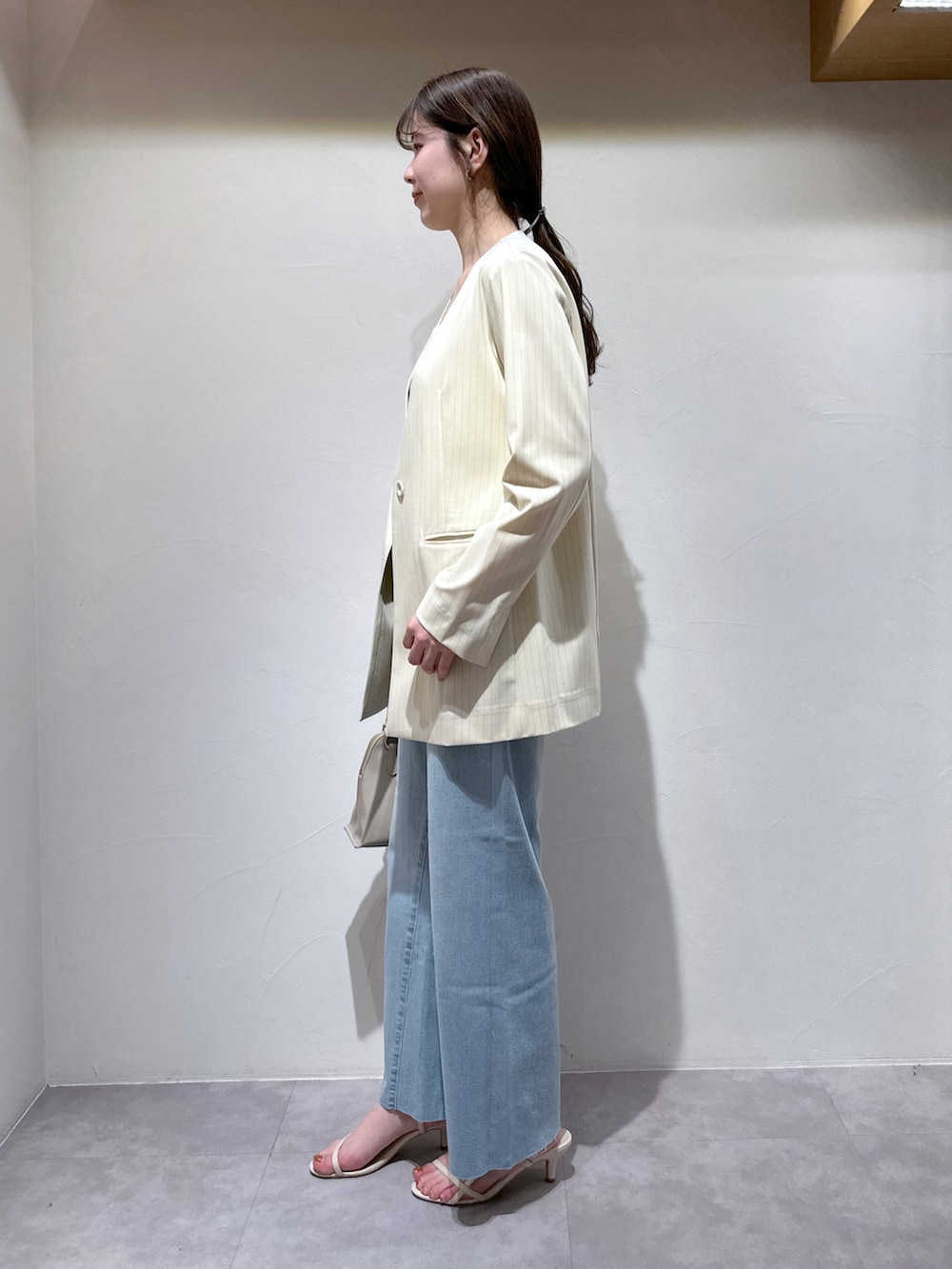 ホワイト系のサンダル、グレー系のショルダーバッグ、ブルー系のデニムパンツを着用したレディースの春コーディネートの3枚目の写真