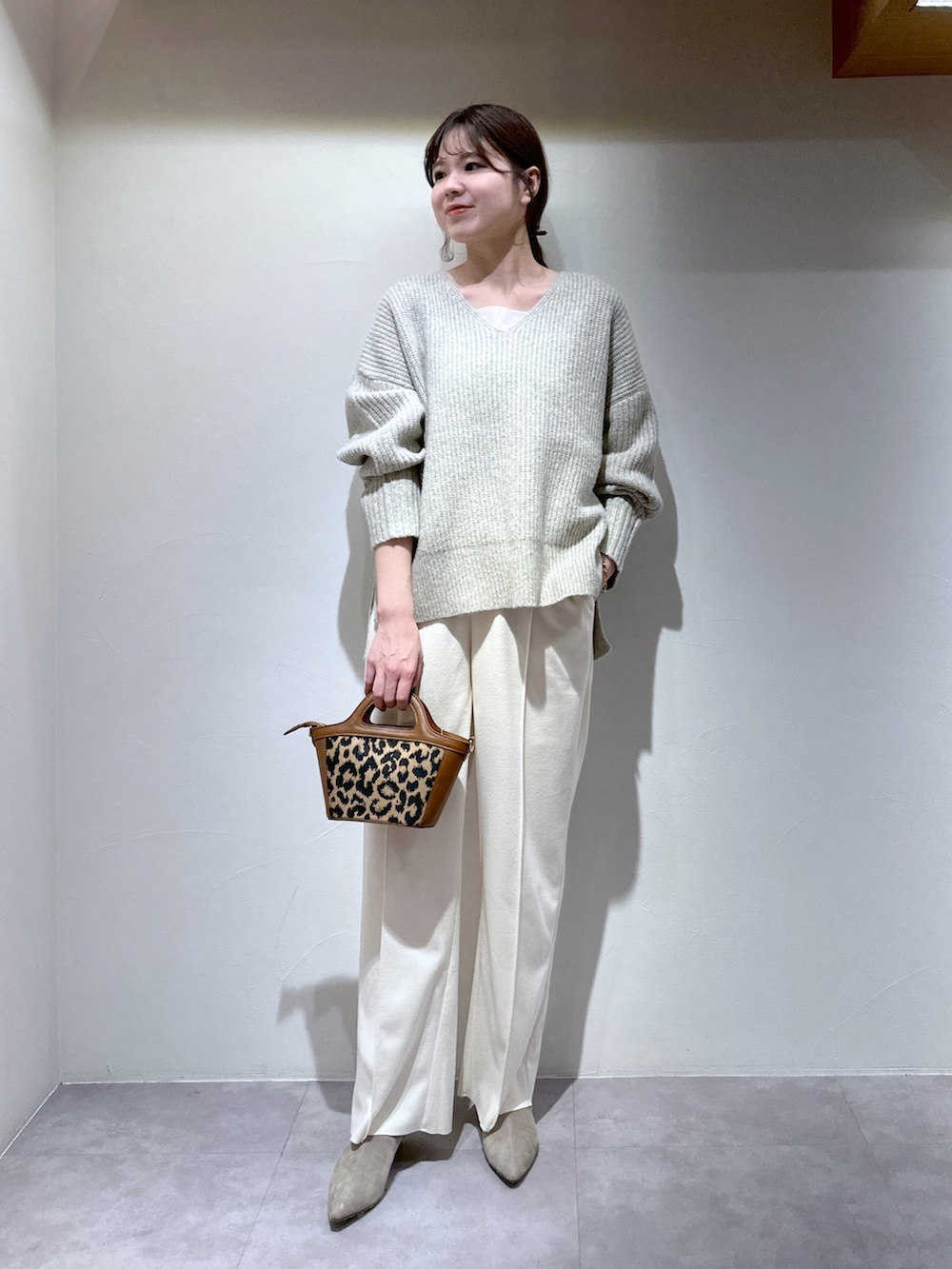 ホワイト系のその他パンツ、ブラック系のショルダーバッグ、ベージュ系のニット/セーターを着用したレディースの冬コーディネートの2枚目の写真