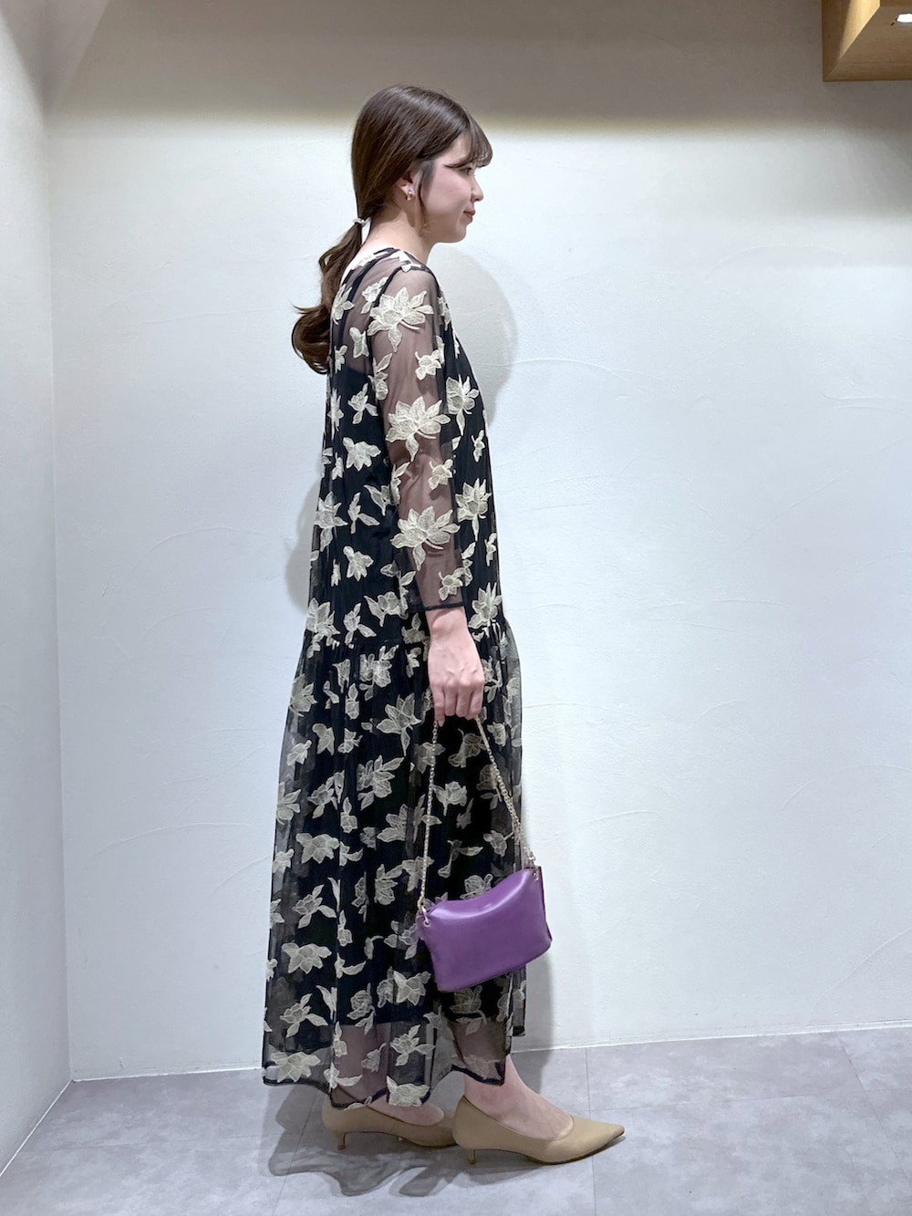 ブラック系のワンピース、パープル系のトートバッグ、ベージュ系のパンプスを着用したレディースの冬コーディネートの5枚目の写真