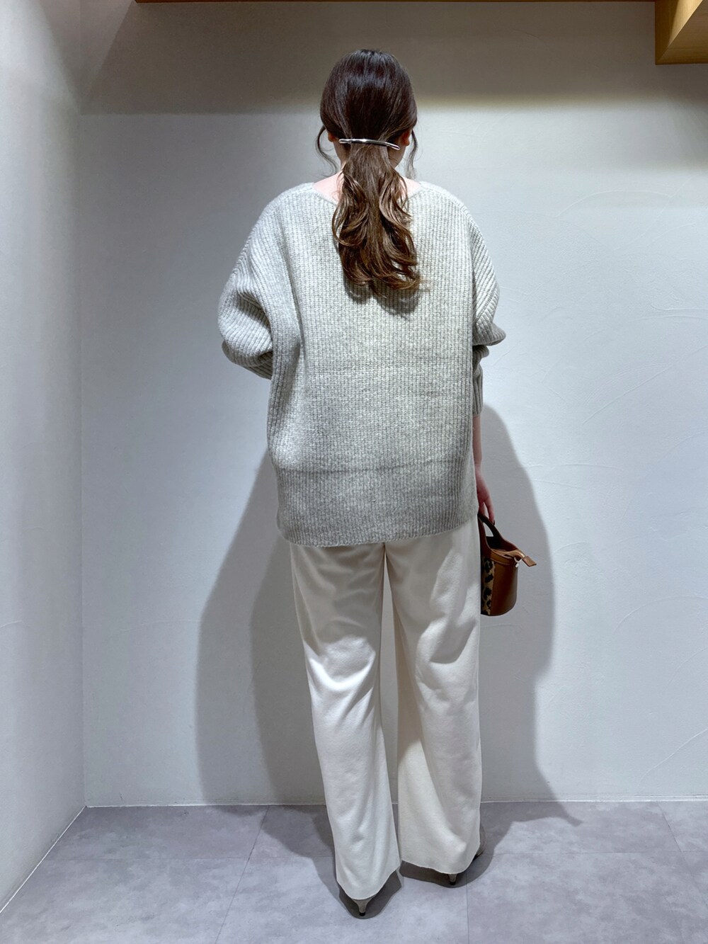 ホワイト系のその他パンツ、ブラック系のショルダーバッグ、ベージュ系のニット/セーターを着用したレディースの冬コーディネートの5枚目の写真