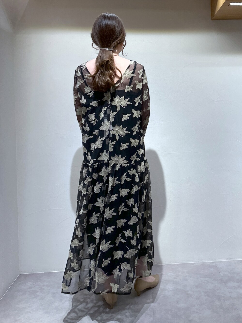 ブラック系のワンピース、パープル系のトートバッグ、ベージュ系のパンプスを着用したレディースの冬コーディネートの4枚目の写真