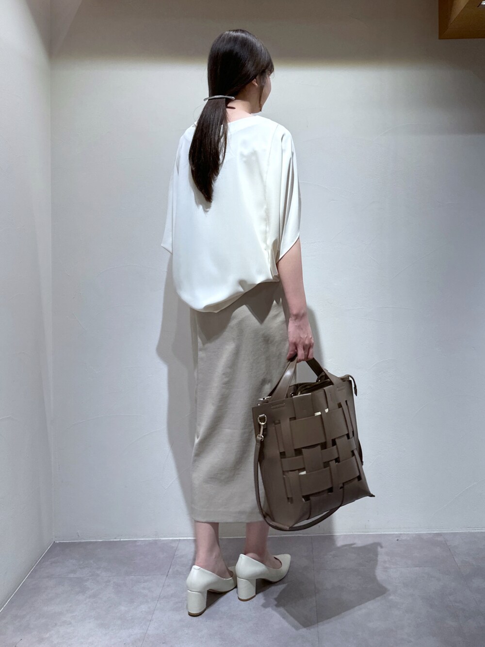 ベージュ系のトートバッグ、ベージュ系のスカート、ホワイト系のシャツ/ブラウスを着用したレディースの春コーディネートの3枚目の写真