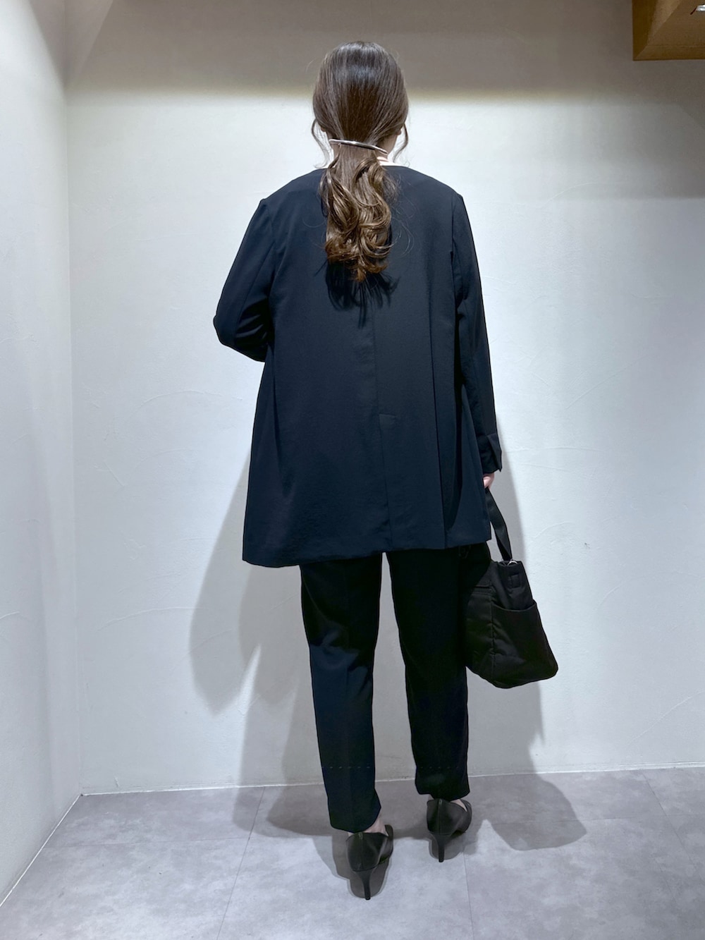 ブラック系のトートバッグ、ブルー系のスラックス、ブルー系のノーカラージャケットを着用したレディースの春コーディネートの4枚目の写真