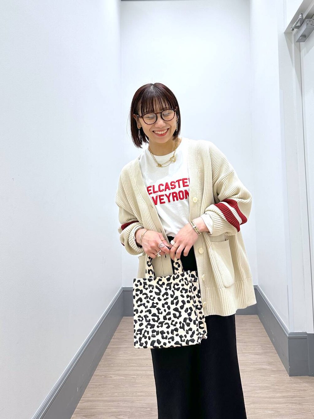 ホワイト系のニット/セーター、ホワイト系のTシャツ/カットソー、ブラック系のスカートを着用したレディースの冬コーディネートの8枚目の写真