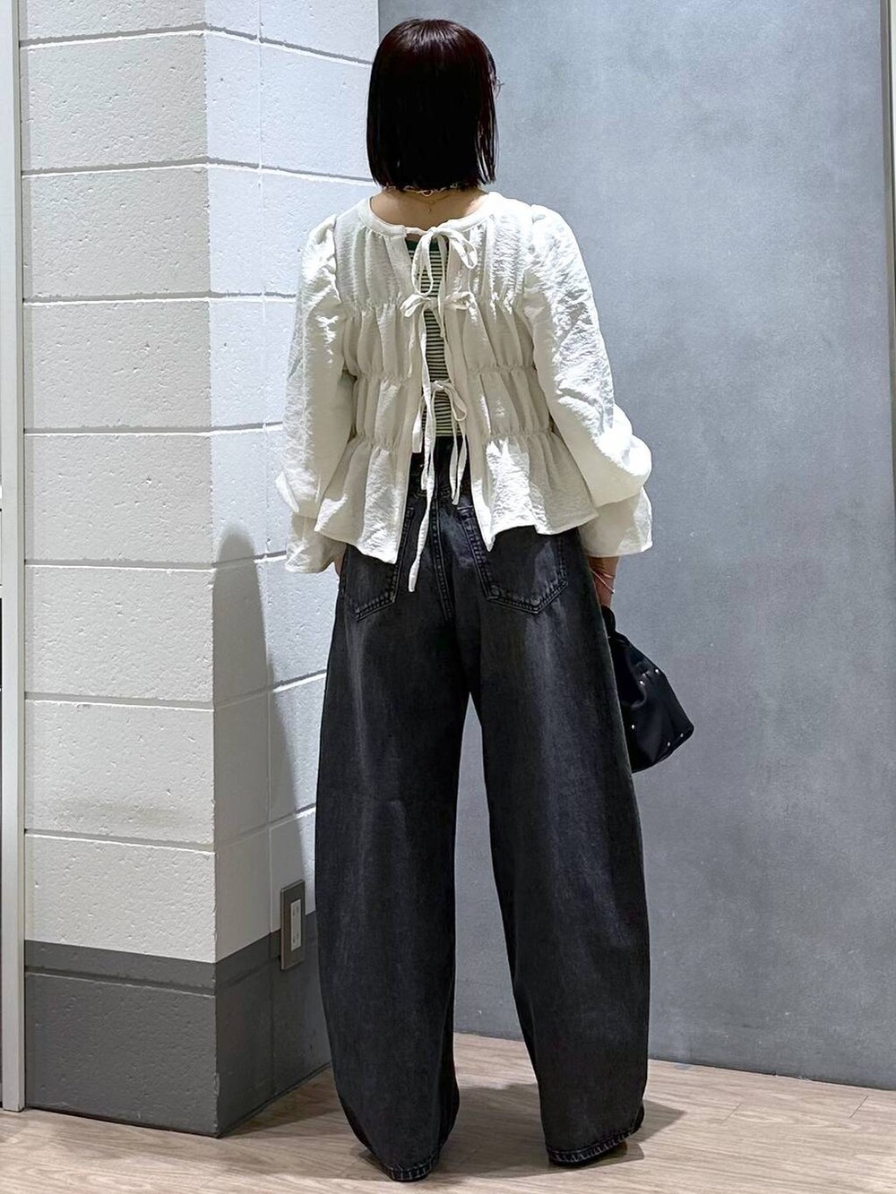 ブラック系のハンドバッグ、グリーン系のタンクトップ、ホワイト系のシャツ/ブラウスを着用したレディースの春コーディネートの5枚目の写真