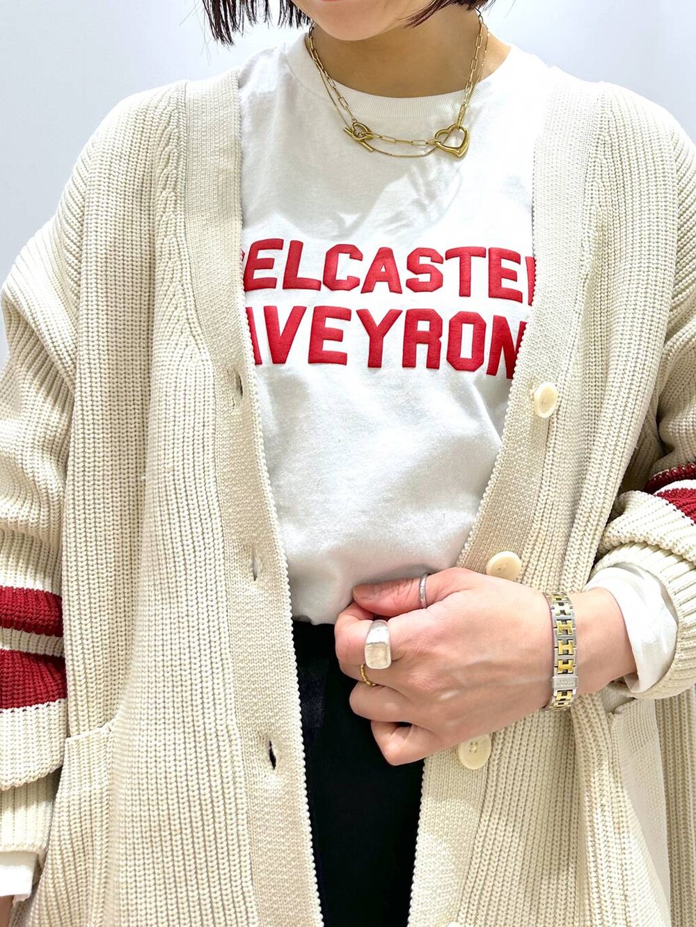ホワイト系のニット/セーター、ホワイト系のTシャツ/カットソー、ブラック系のスカートを着用したレディースの冬コーディネートの7枚目の写真