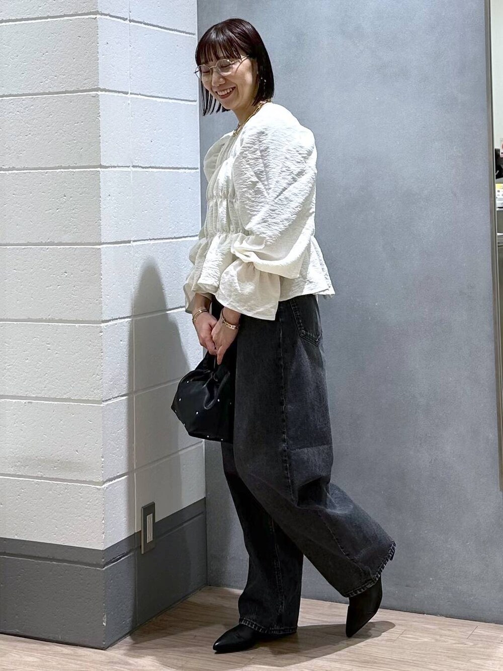 ブラック系のハンドバッグ、グリーン系のタンクトップ、ホワイト系のシャツ/ブラウスを着用したレディースの春コーディネートの3枚目の写真