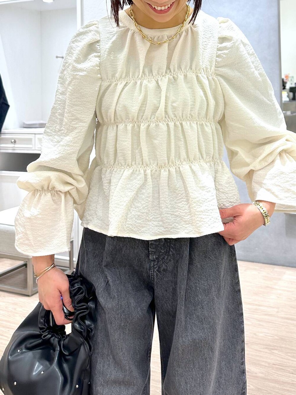 ブラック系のハンドバッグ、グリーン系のタンクトップ、ホワイト系のシャツ/ブラウスを着用したレディースの春コーディネートの6枚目の写真