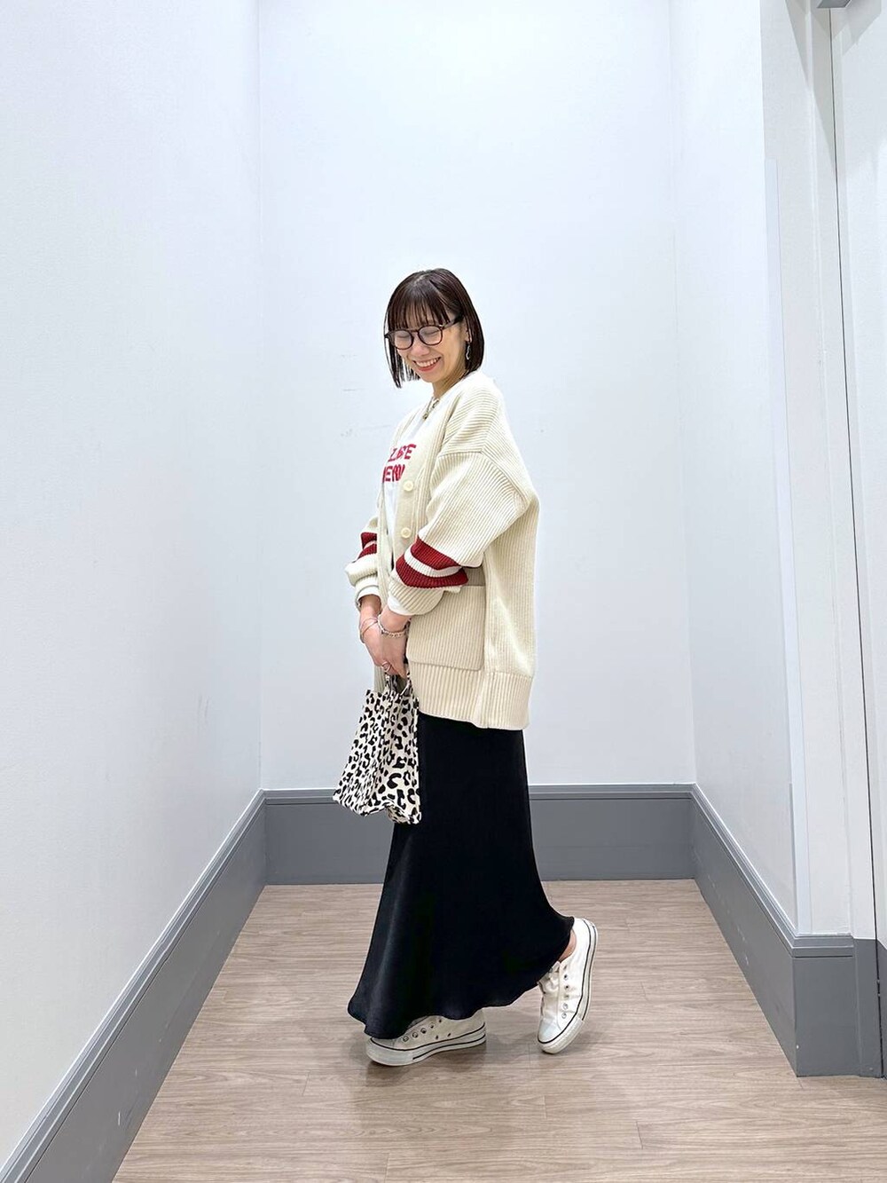 ホワイト系のニット/セーター、ホワイト系のTシャツ/カットソー、ブラック系のスカートを着用したレディースの冬コーディネートの3枚目の写真