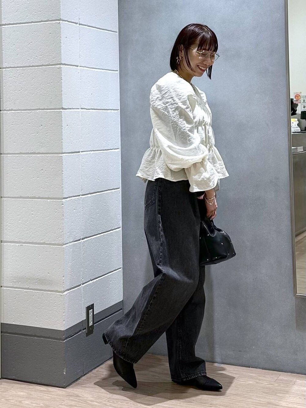 ブラック系のハンドバッグ、グリーン系のタンクトップ、ホワイト系のシャツ/ブラウスを着用したレディースの春コーディネートの2枚目の写真