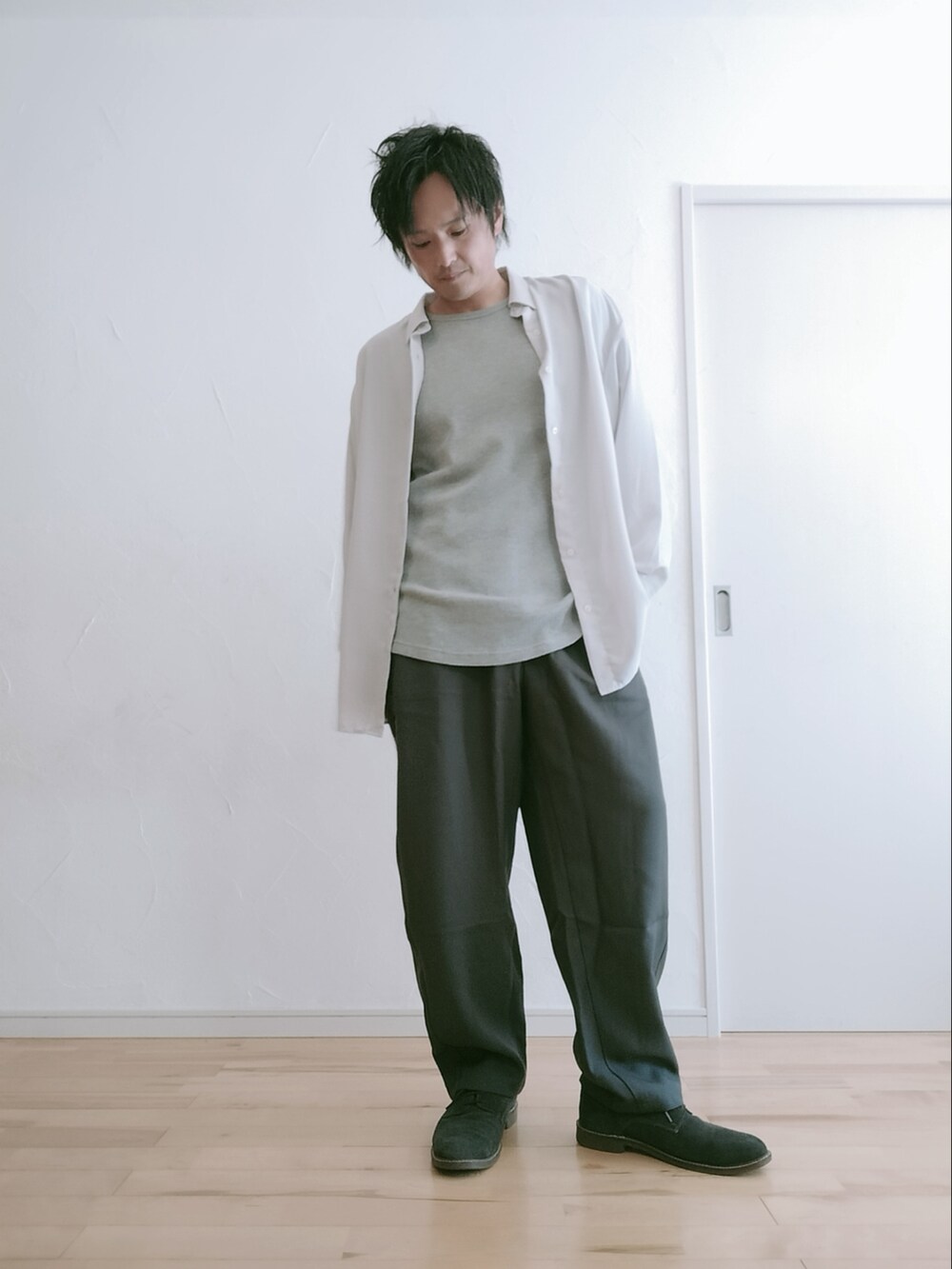 グレー系のスラックス、グレー系のシャツ/ブラウス、グレー系のTシャツ/カットソーを着用したメンズの冬コーディネートの2枚目の写真