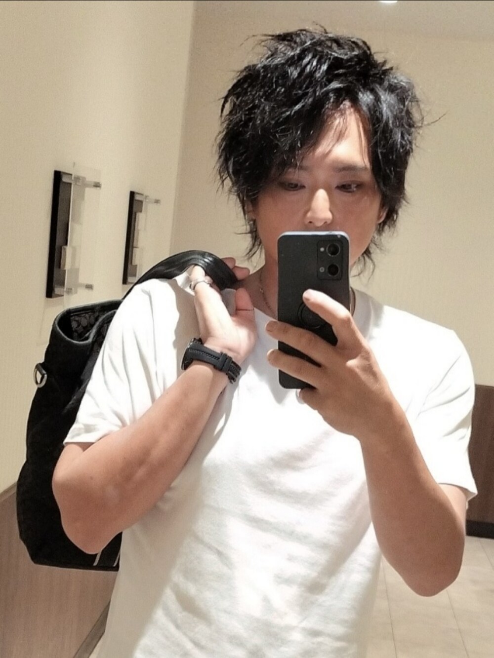 ホワイト系のTシャツ/カットソー、ブルー系のデニムパンツ、ブラック系のトートバッグを着用したメンズの夏コーディネートの2枚目の写真
