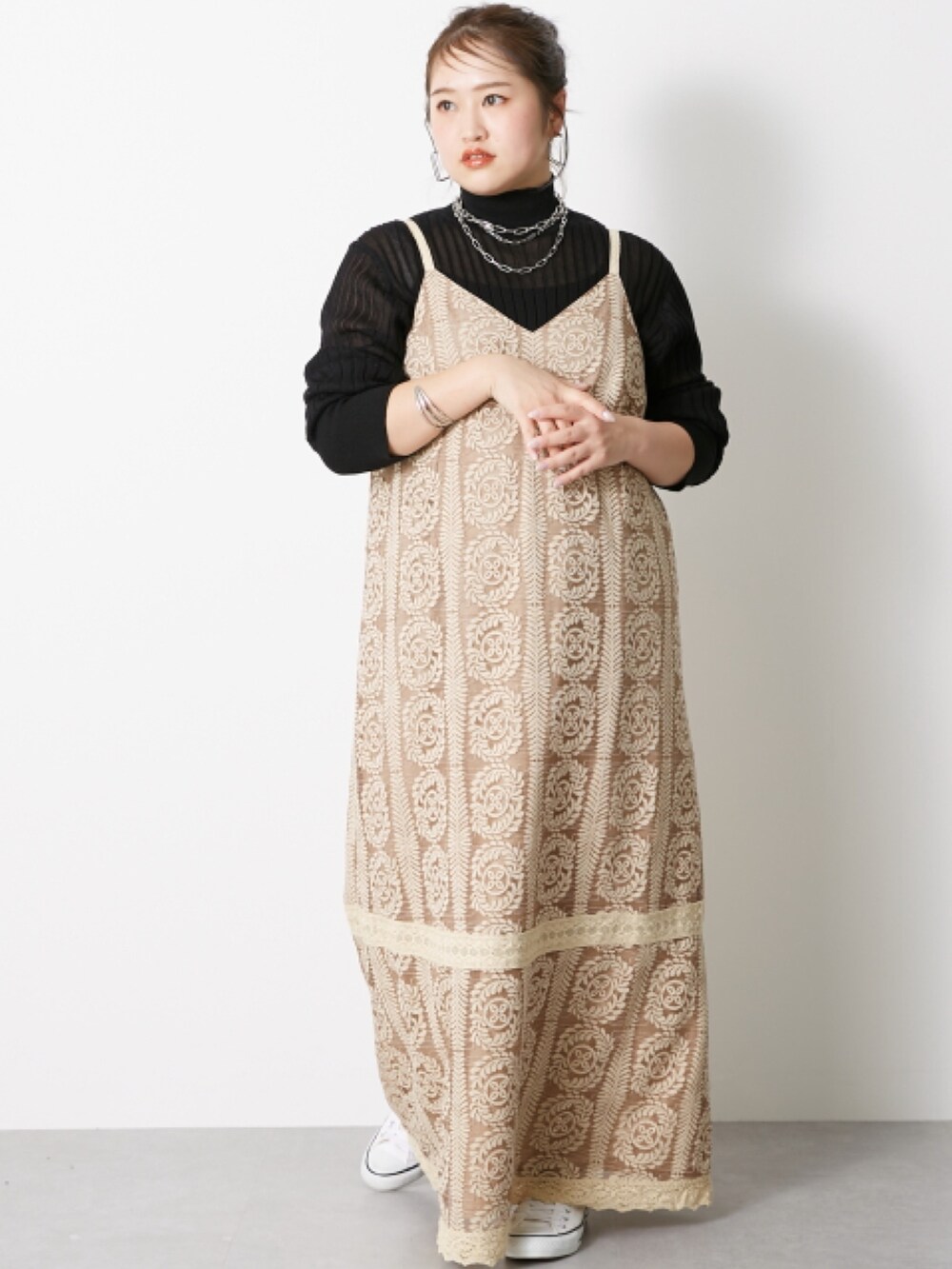 ブラック系のニット/セーター、ベージュ系のワンピースを着用したレディースの冬コーディネートの2枚目の写真