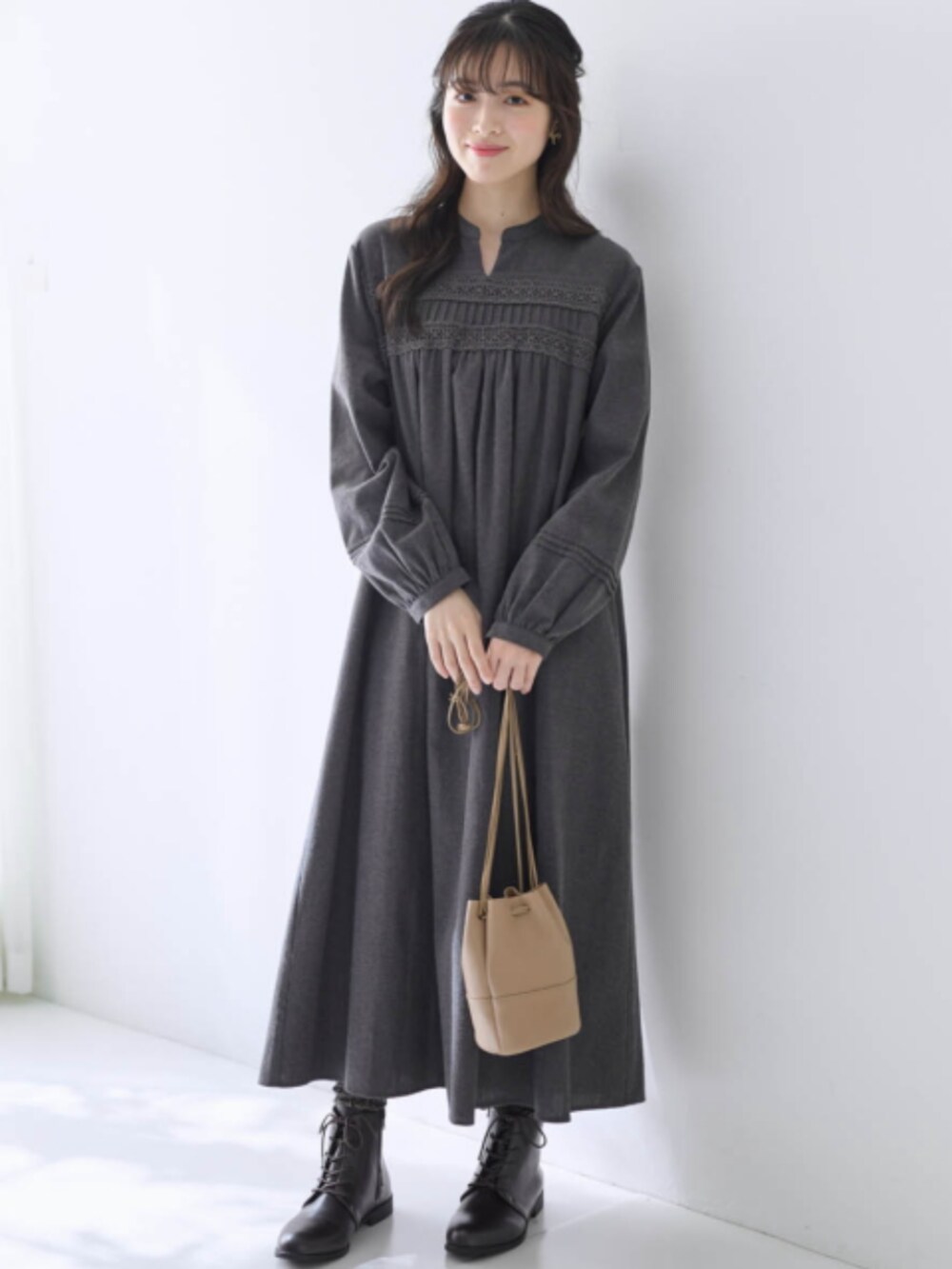 グレー系のワンピース、ホワイト系のベストを着用したレディースの秋コーディネートの2枚目の写真