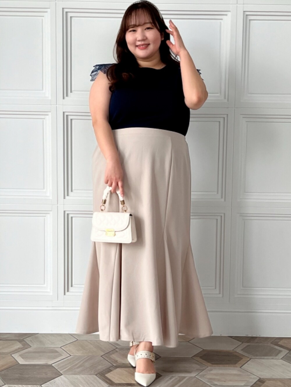 ブルー系のニット/セーター、ホワイト系のカーディガン/ボレロ、グレー系のスカートを着用したレディースの春コーディネートの2枚目の写真