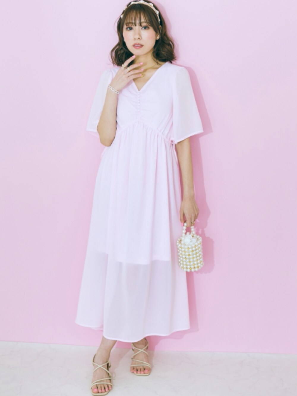 ピンク系のワンピース、ホワイト系のカーディガン/ボレロを着用したレディースの春コーディネートの2枚目の写真