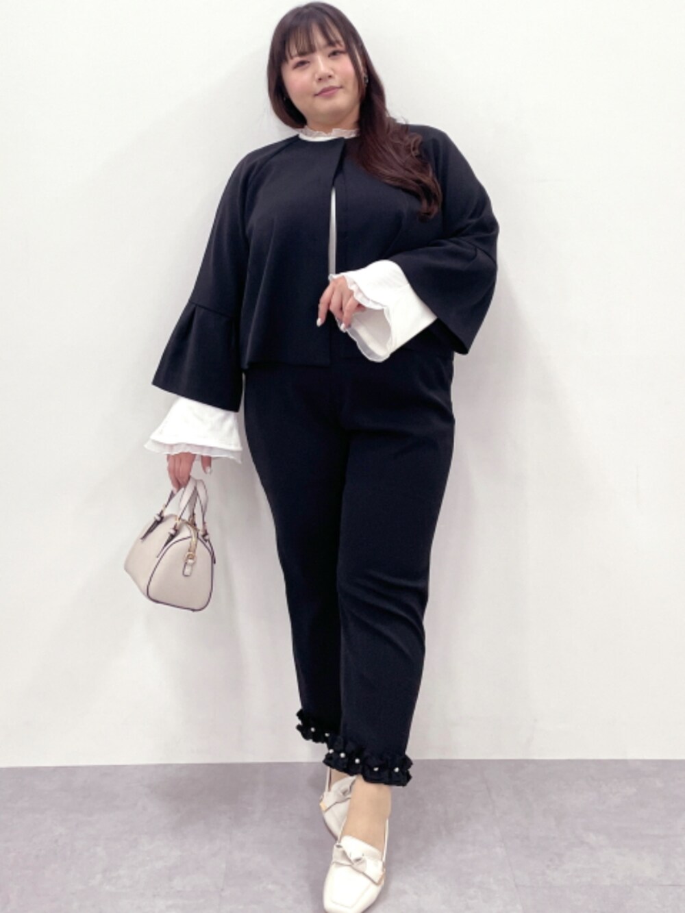 ブラック系のその他パンツ、ホワイト系のTシャツ/カットソー、ブラック系のノーカラージャケットを着用したレディースの冬コーディネートの2枚目の写真