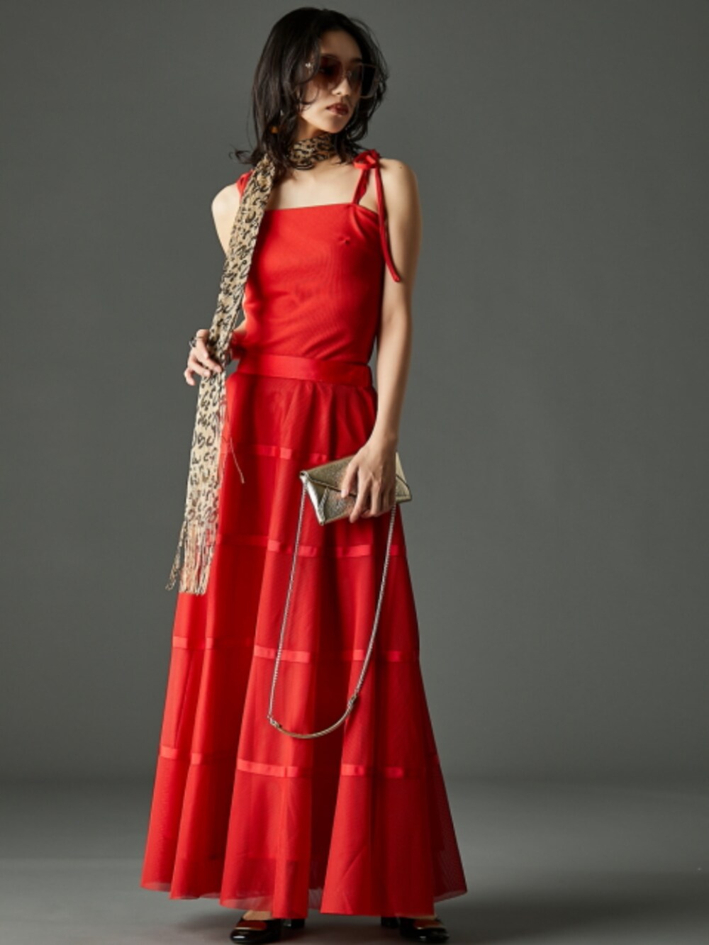 グレー系のデニムジャケット、レッド系のキャミソール、レッド系のスカートを着用したレディースの春コーディネートの2枚目の写真