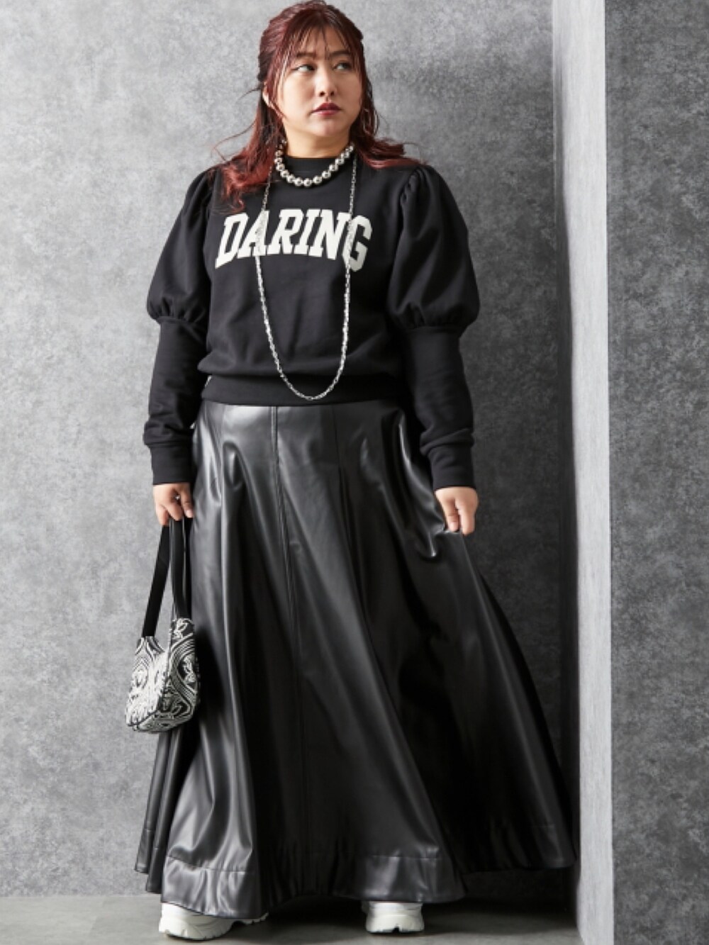 ブラック系のスウェット、ブラック系のスカートを着用したレディースの冬コーディネートの2枚目の写真