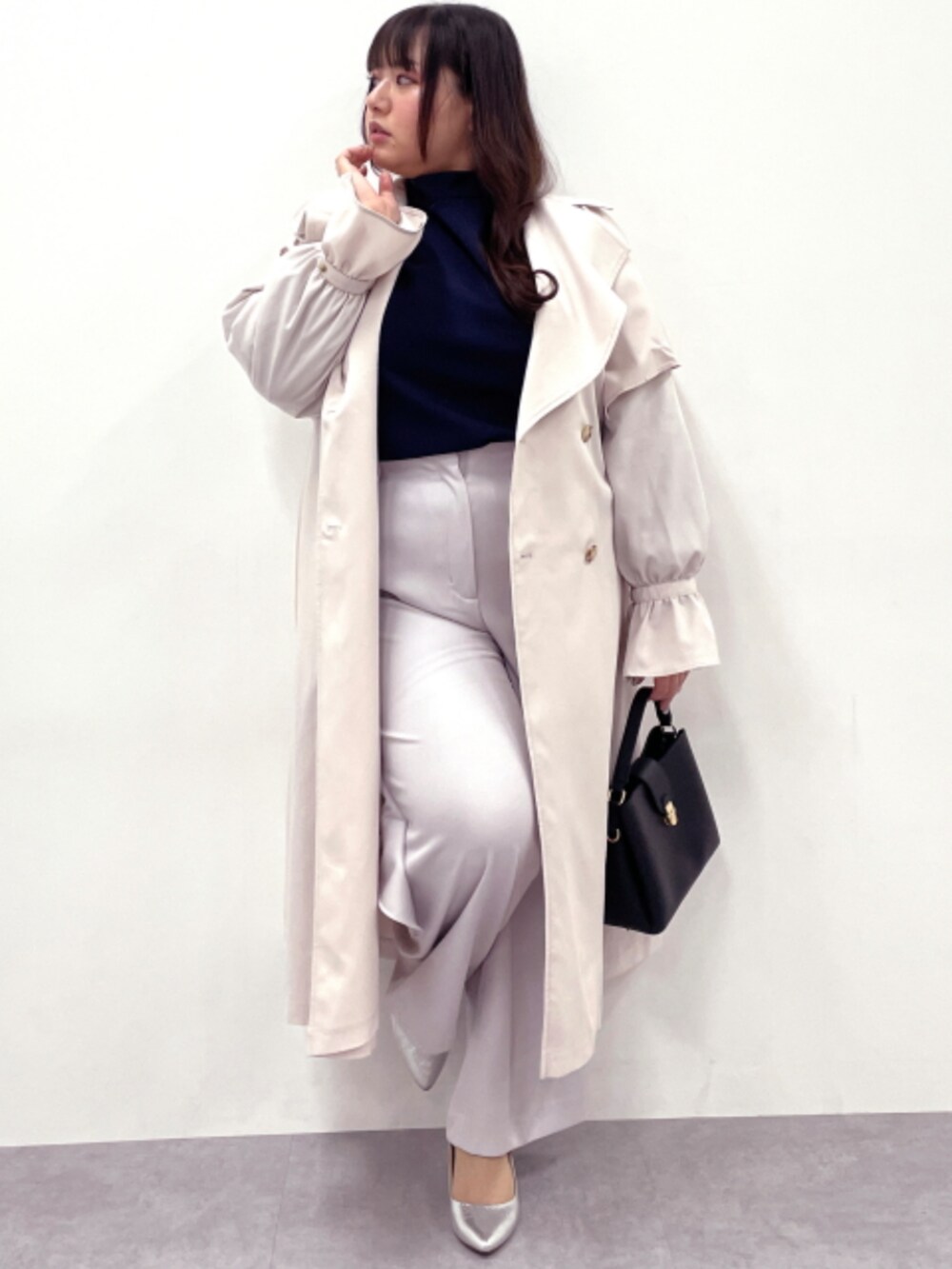 ブルー系のTシャツ/カットソー、ベージュ系のスラックス、ホワイト系のトレンチコートを着用したレディースの冬コーディネートの3枚目の写真