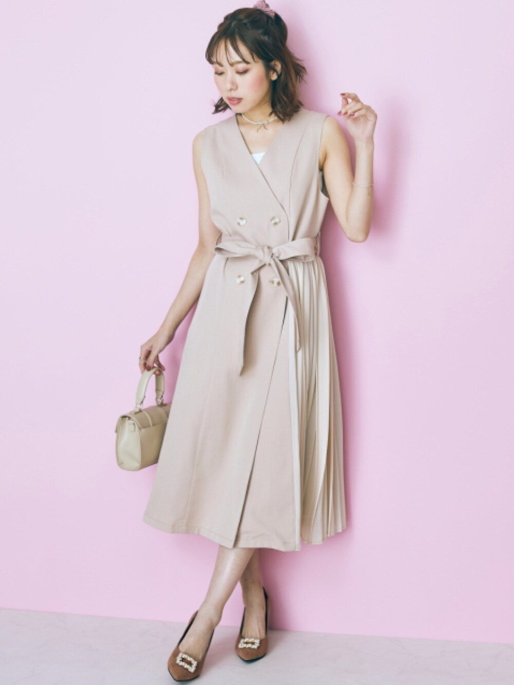 ブルー系のデニムパンツ、ベージュ系のジャケット/アウター、ホワイト系のキャミソールを着用したレディースの冬コーディネートの2枚目の写真