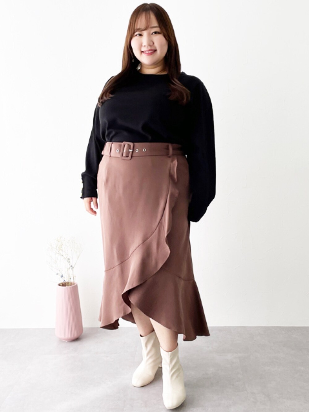 ブラック系のニット/セーター、ブラウン系のスカートを着用したレディースの秋コーディネートの2枚目の写真