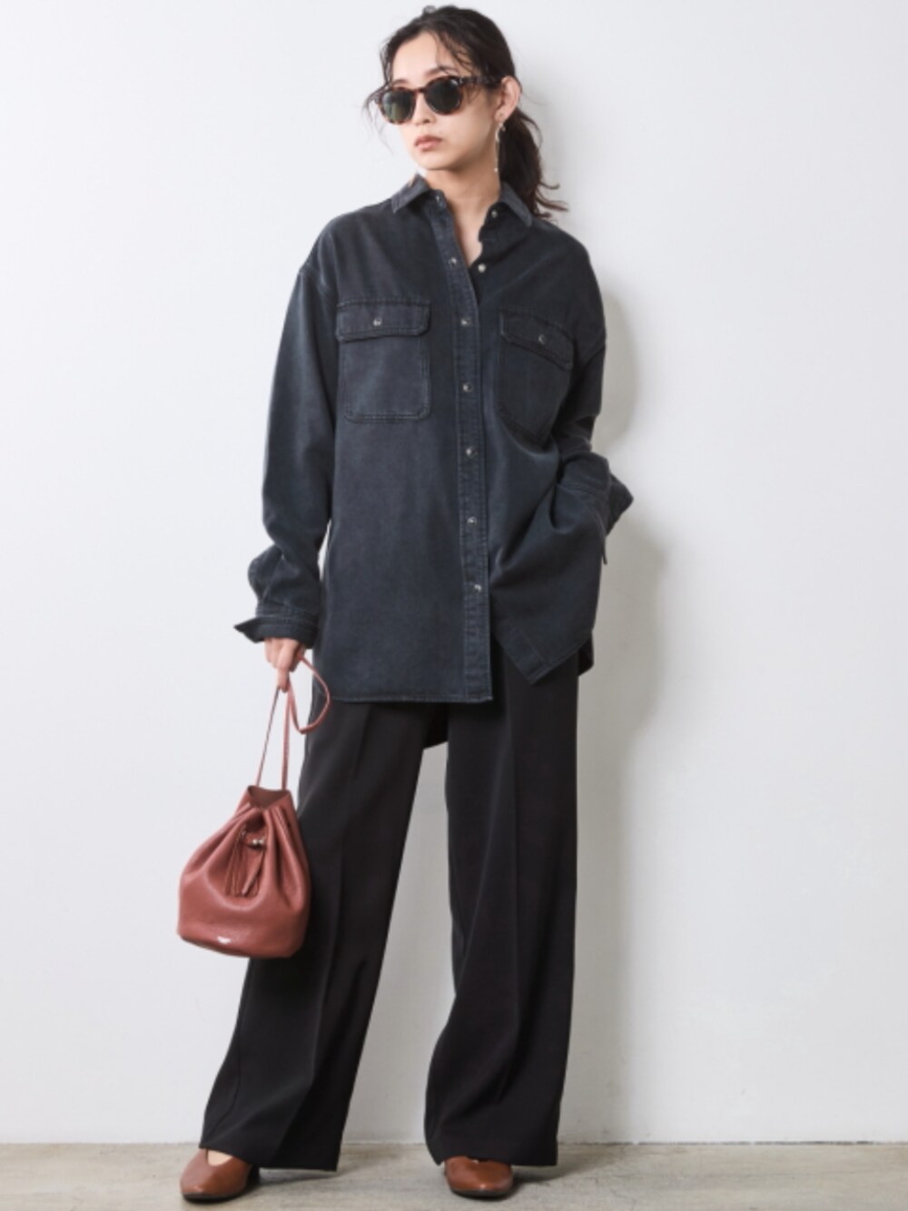 ブラック系のスラックス、ブラウン系のベスト、ブラック系のシャツ/ブラウスを着用したレディースの秋コーディネートの2枚目の写真